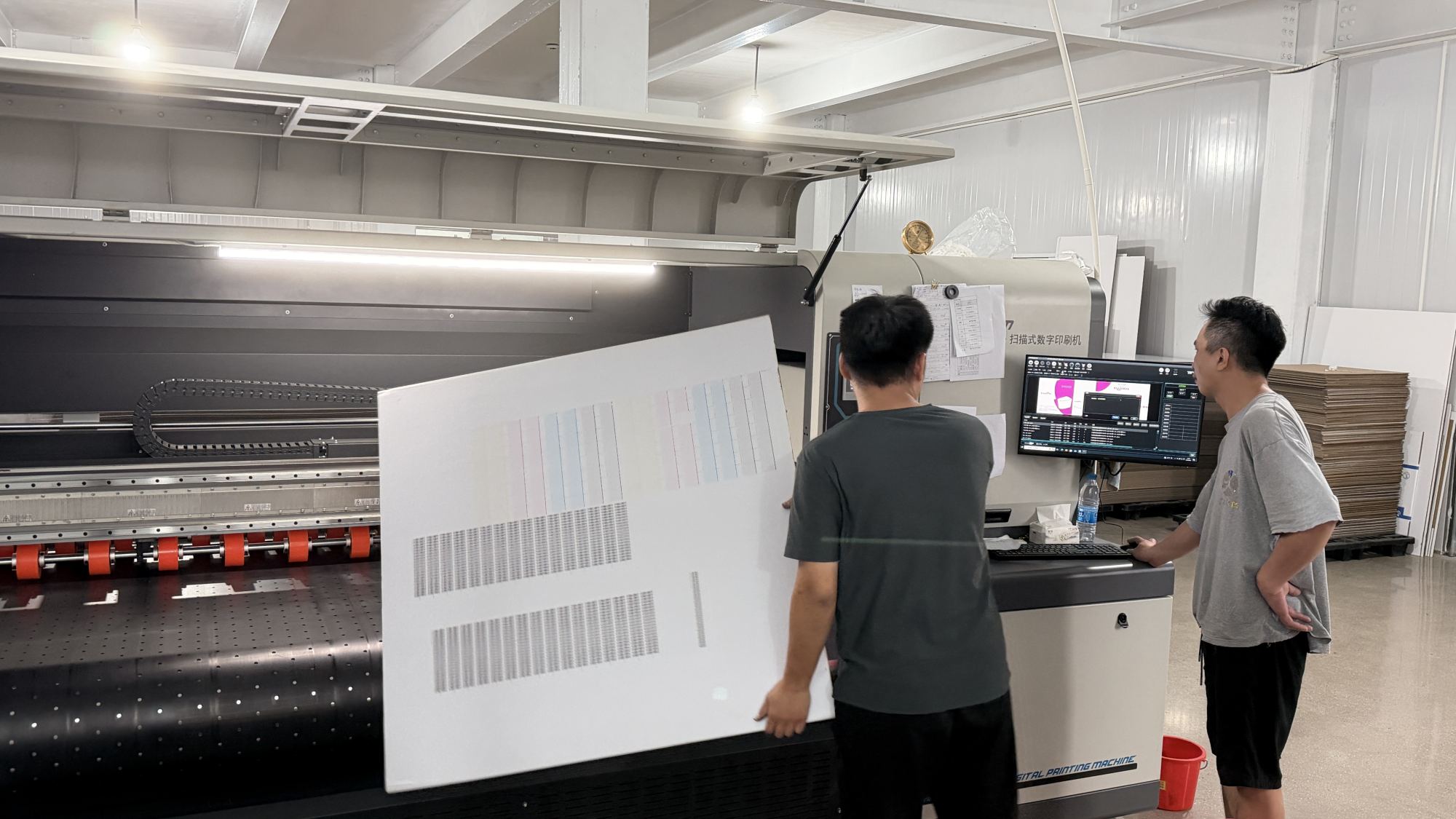 Technicians checking print calibration beside digital printing equipment